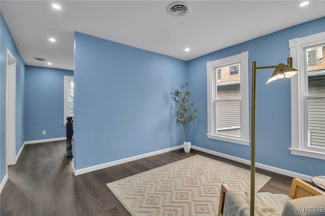 interior space with wood finished floors, visible vents, and baseboards