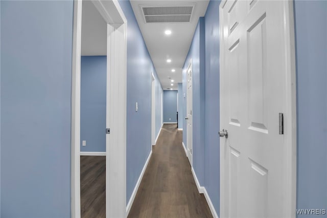 corridor with dark wood-type flooring, recessed lighting, baseboards, and visible vents