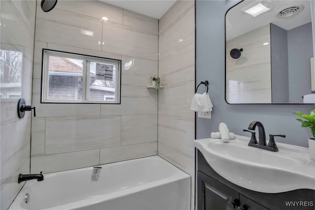 full bath with visible vents, vanity, and shower / bathtub combination