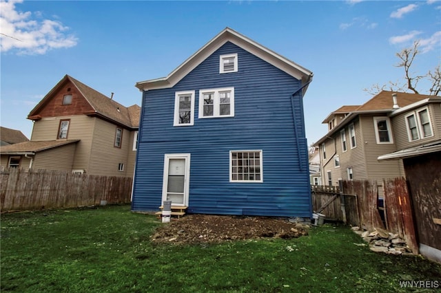 back of property featuring a fenced backyard and a yard