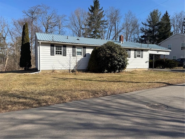 view of front of house with a carport, a front lawn, driveway, and metal roof