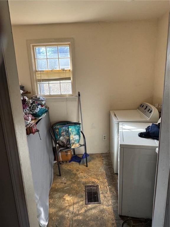 clothes washing area featuring washer and dryer, visible vents, and laundry area