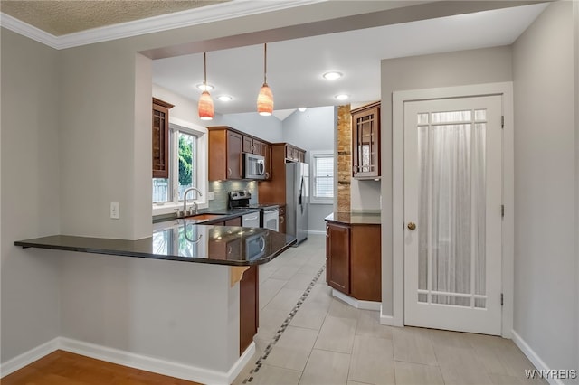 kitchen featuring glass insert cabinets, baseboards, appliances with stainless steel finishes, a peninsula, and a sink