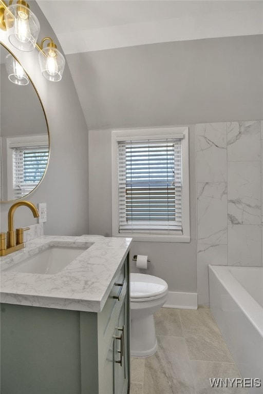 full bath with toilet, a tub to relax in, baseboards, vanity, and vaulted ceiling