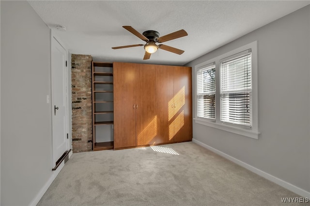 unfurnished bedroom featuring baseboards, carpet, ceiling fan, and a textured ceiling