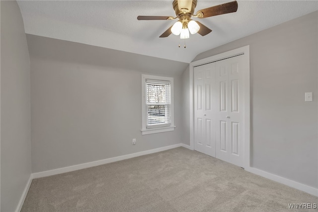 unfurnished bedroom with baseboards, carpet flooring, and vaulted ceiling