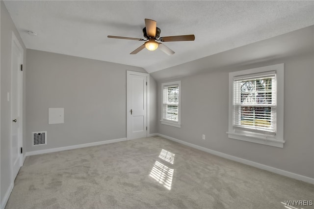 empty room with visible vents, ceiling fan, light colored carpet, and baseboards