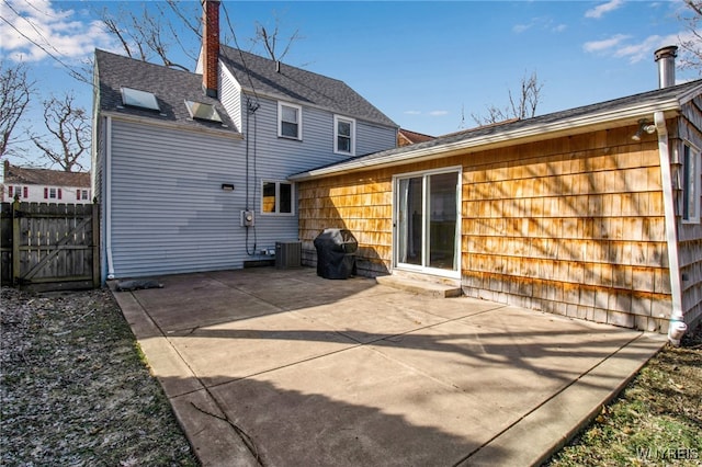 back of house with central air condition unit, fence, a chimney, and a patio area