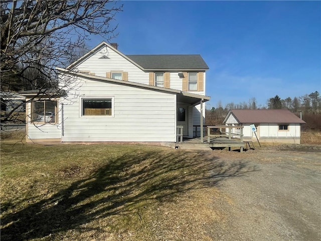 rear view of house with a lawn and a chimney