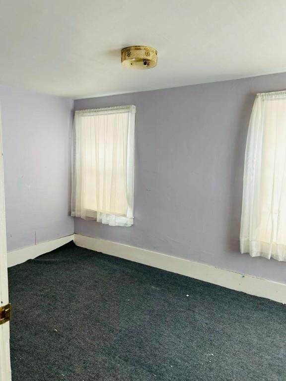 carpeted empty room with baseboards