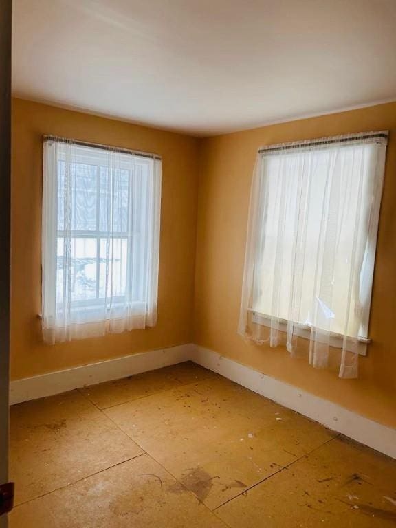 unfurnished room with baseboards