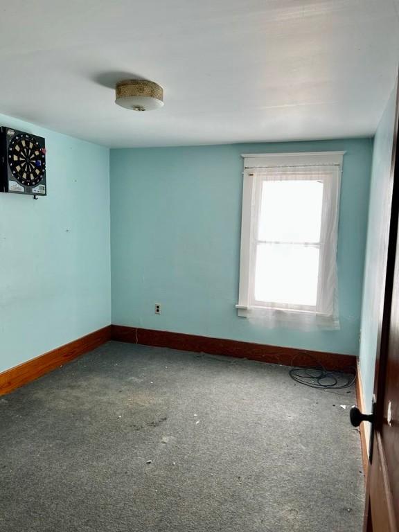 spare room featuring baseboards and carpet