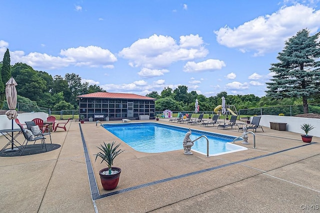 pool with a patio and fence