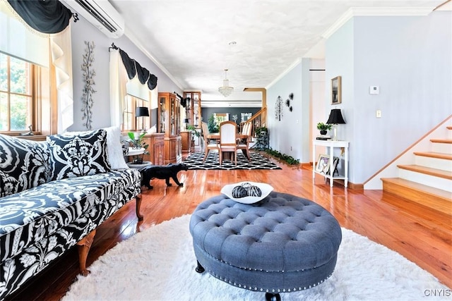 living area featuring stairs, crown molding, wood finished floors, and a wall mounted air conditioner