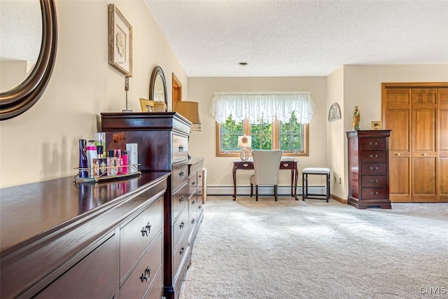 kitchen with a baseboard heating unit, light colored carpet, baseboards, and a textured ceiling