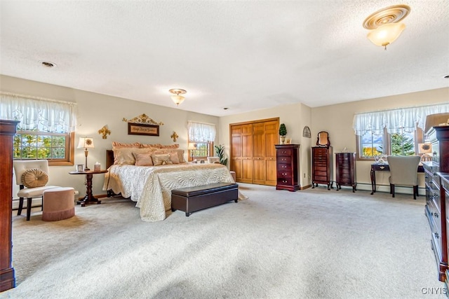 carpeted bedroom with a closet, a textured ceiling, baseboards, and a baseboard radiator