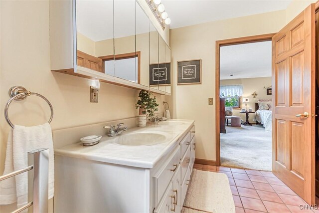 full bathroom with double vanity, tile patterned floors, baseboards, and a sink