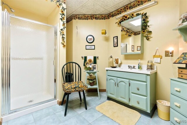 bathroom featuring vanity, baseboards, a stall shower, and tile patterned flooring