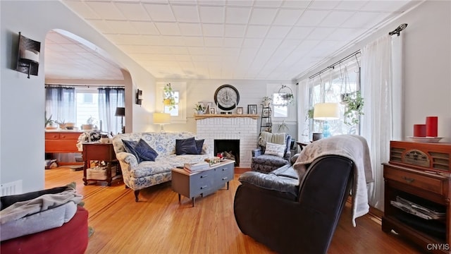 1644 Saint Agnes Ave, Utica, NY 13501 - living room featuring a brick fireplace, wood finished floors, and a wealth of natural light