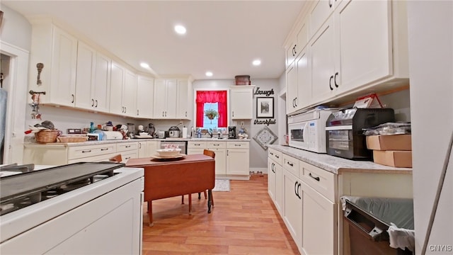 1644 Saint Agnes Ave, Utica, NY 13501 - kitchen with white cabinets, light wood-style floors, white appliances, light countertops, and recessed lighting