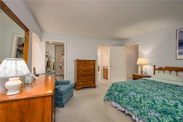 123 Sunset Ridge Rd, Otsego, NY 13326 - bedroom with a walk in closet, light colored carpet, a closet, and ensuite bathroom