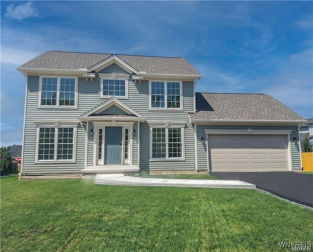 view of front of house featuring a front lawn, an attached garage, driveway, and a shingled roof
