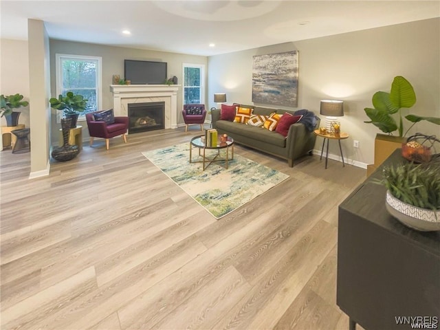 living area featuring a wealth of natural light, wood finished floors, and a fireplace