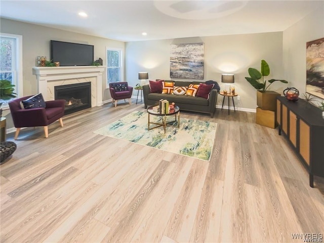 living room featuring wood finished floors, recessed lighting, a fireplace, and baseboards
