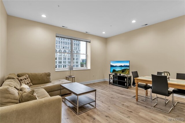 living area featuring recessed lighting, light wood-style floors, and visible vents