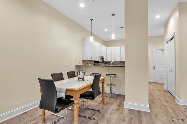 dining room featuring baseboards and light wood finished floors