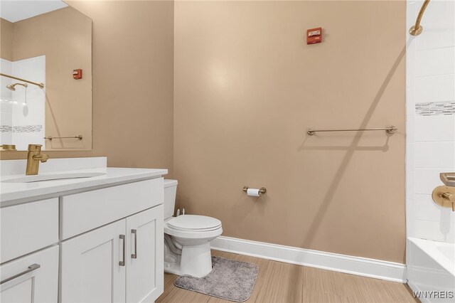 full bathroom featuring vanity, wood finished floors, baseboards, toilet, and shower / bathtub combination