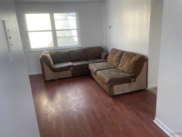 living area with baseboards and wood finished floors