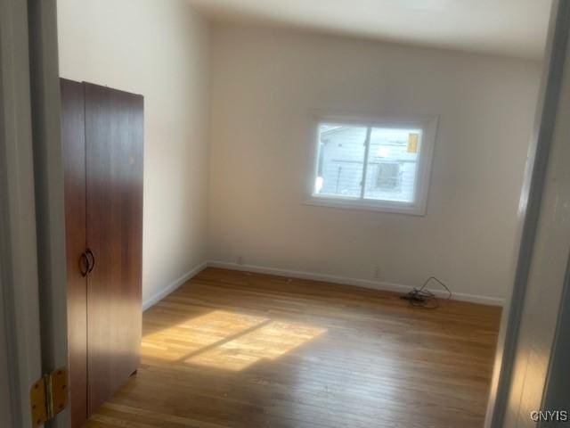 unfurnished bedroom with baseboards and light wood-style flooring