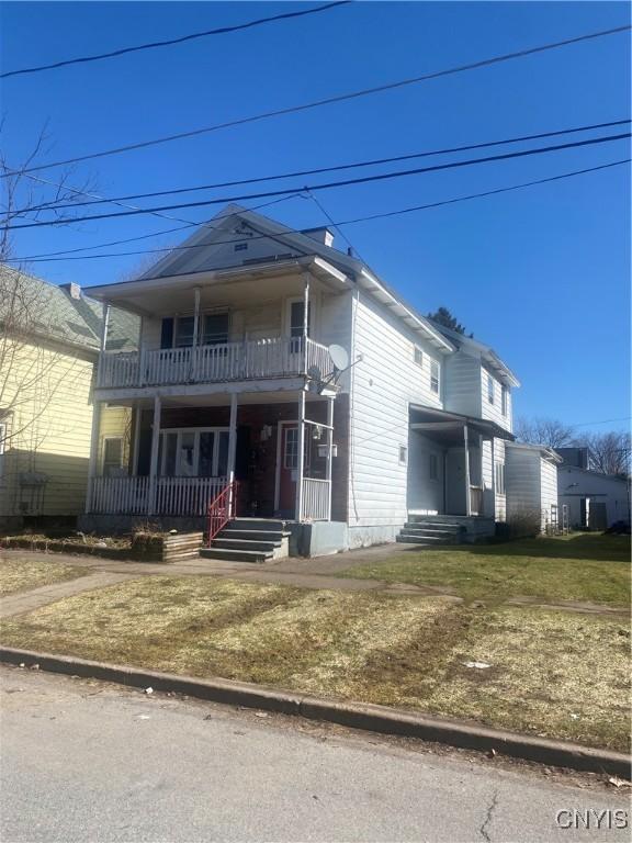 view of front of property featuring a balcony and a porch