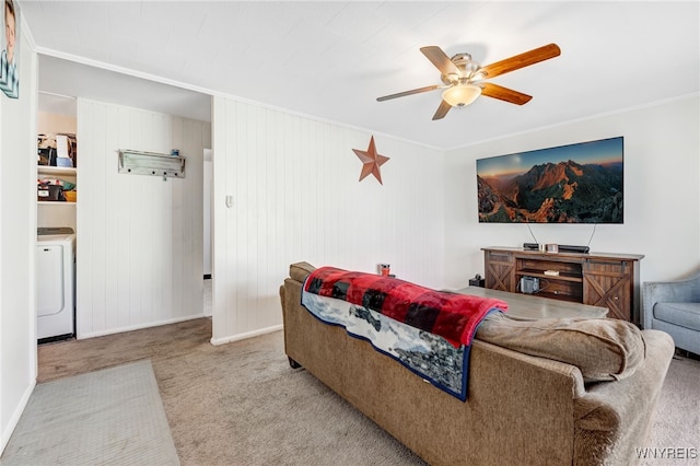 carpeted living room with baseboards, washer / dryer, ceiling fan, and crown molding