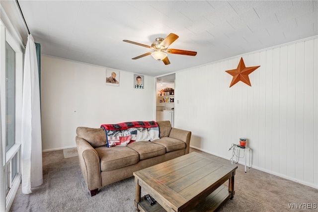 living area featuring ceiling fan, light carpet, and washer and clothes dryer