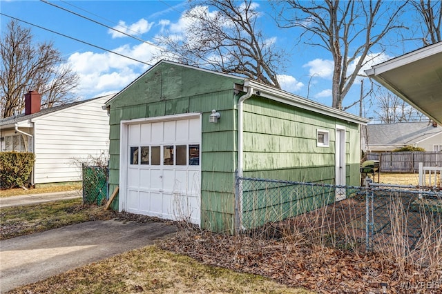 detached garage with aphalt driveway and fence