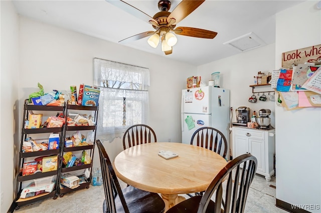 dining space with attic access and ceiling fan