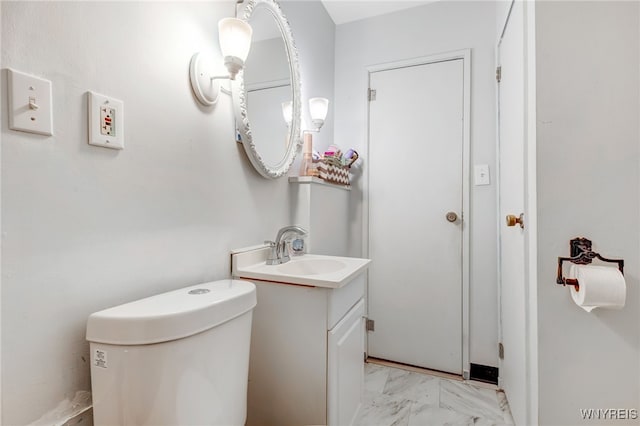 bathroom featuring toilet, marble finish floor, and vanity