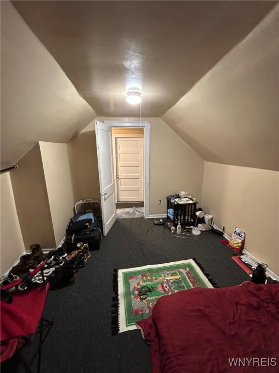 interior space with baseboards, lofted ceiling, and carpet flooring