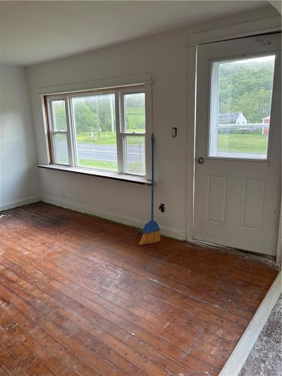 interior space with a wealth of natural light, baseboards, and hardwood / wood-style floors