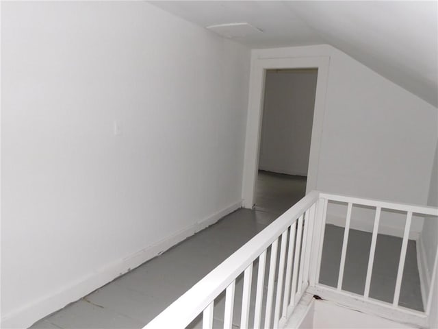 hallway featuring baseboards and lofted ceiling
