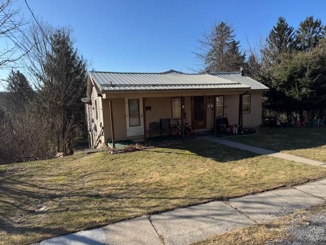 view of front of home featuring a front yard, covered porch, and metal roof