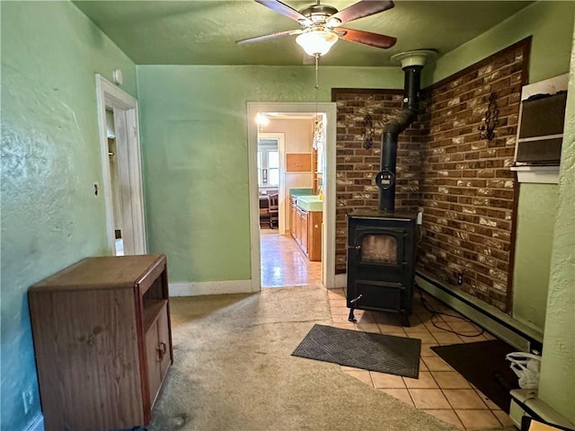 7 Hedgehog Ln, Bradford-Town, PA 16701 - living room featuring a wood stove, a ceiling fan, a baseboard heating unit, and light tile patterned flooring