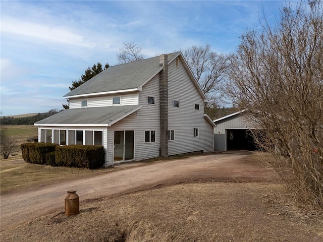 7317 County Highway 33, Kortright, NY 13739 - exterior space with an outdoor structure, a garage, dirt driveway, and roof with shingles