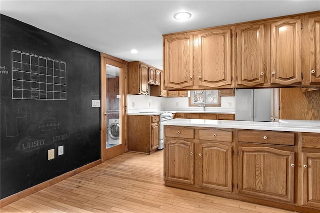 7317 County Highway 33, Kortright, NY 13739 - kitchen featuring electric range, washer / clothes dryer, light wood-style flooring, and light countertops