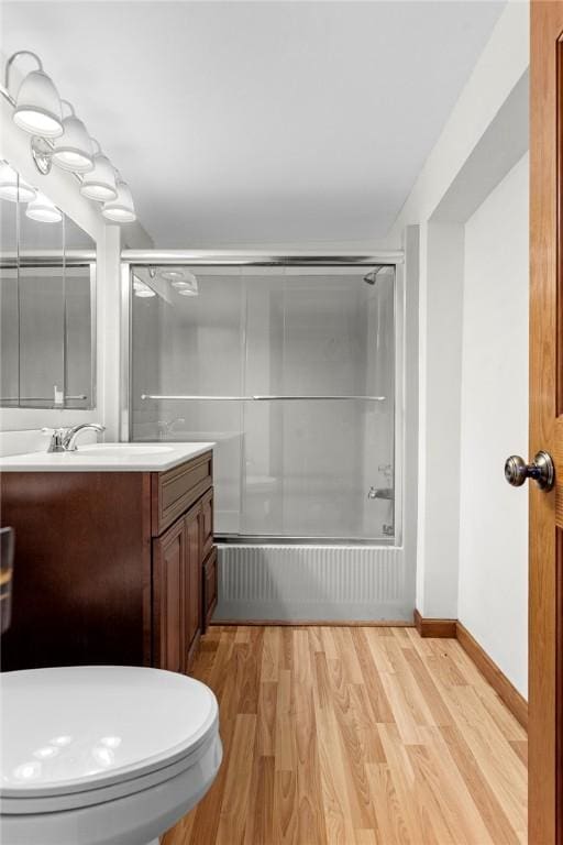 7317 County Highway 33, Kortright, NY 13739 - bathroom featuring baseboards, toilet, wood finished floors, combined bath / shower with glass door, and vanity