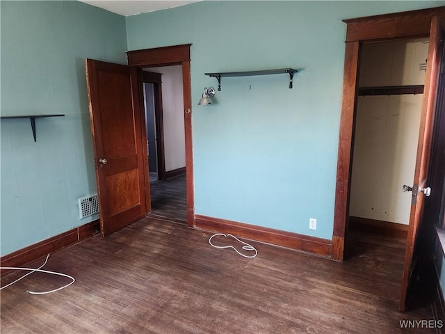 unfurnished bedroom featuring visible vents, baseboards, and wood finished floors