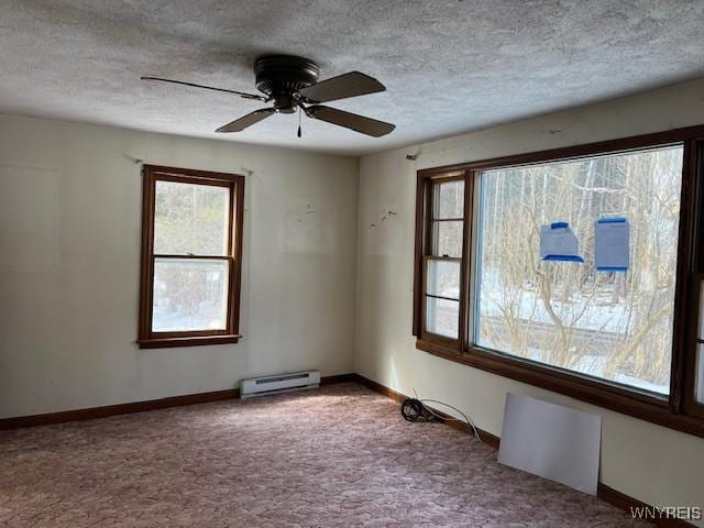 spare room with a baseboard radiator, carpet, a textured ceiling, ceiling fan, and baseboards