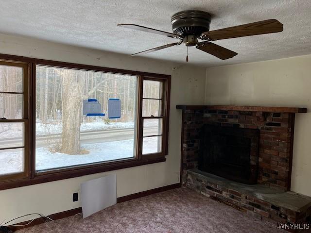 unfurnished living room featuring carpet flooring, a textured ceiling, a fireplace, ceiling fan, and baseboards